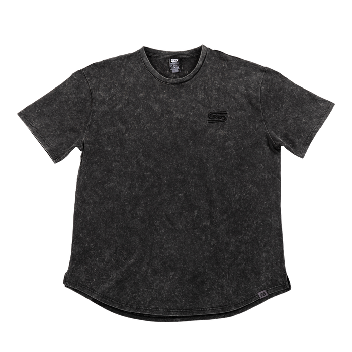 Close-up of black stonewash fabric with a gray tag featuring a black stylized "GS" logo near the hem.
